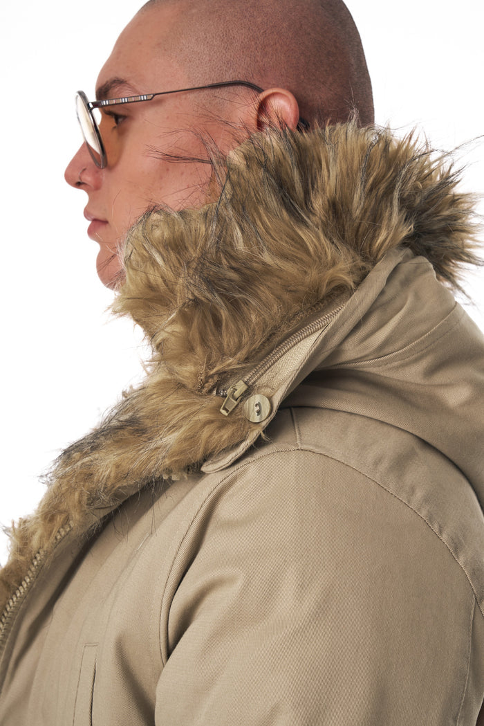 Martin Valen beige parka jacket side view, thick furry collar framing the face with a decorative button near the hood
