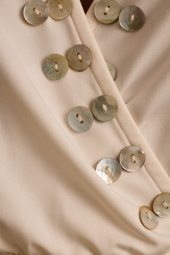 Close-up of mother-of-pearl shell buttons on the ivory Venice halter top.
