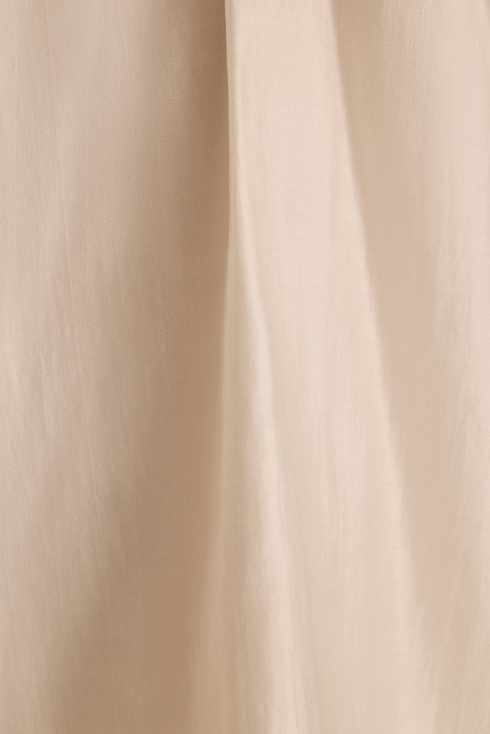 Close-up of the Zella halter top's ivory fabric draping in soft vertical folds.