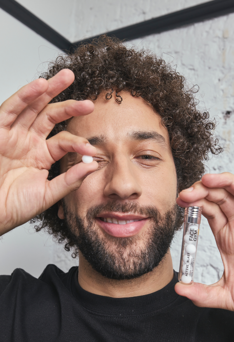 a man holding a small white pill in a tube