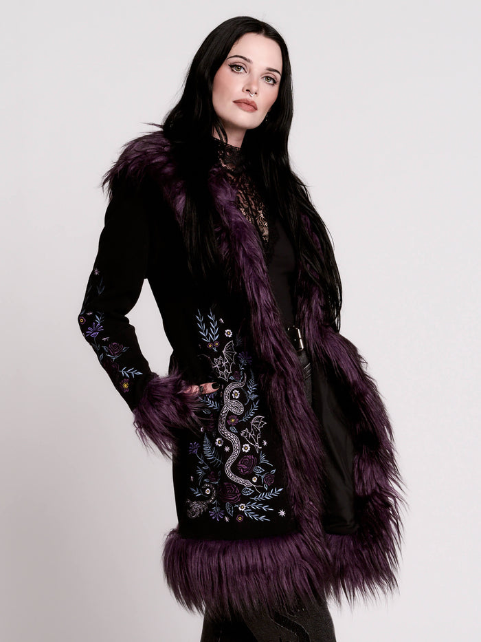 This mid-length black coat pairs a soft, suede-like finish with plush amethyst-purple faux fur trim