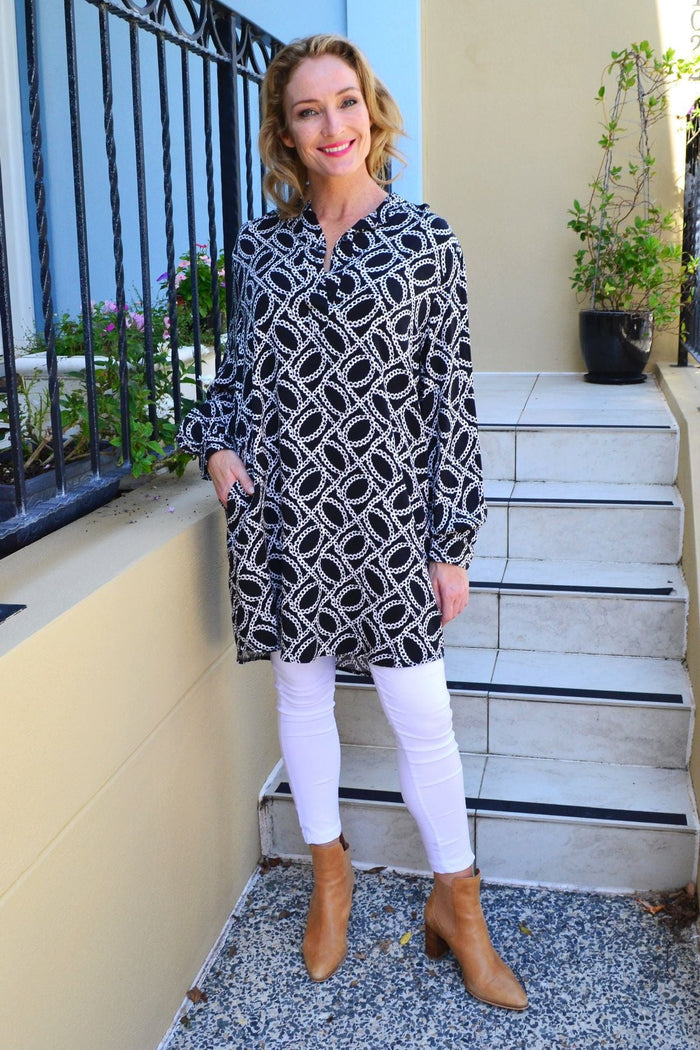 Black and white link tunic shirt by Caroline Morgan displayed on a hanger with detailed fabric texture and classic design.