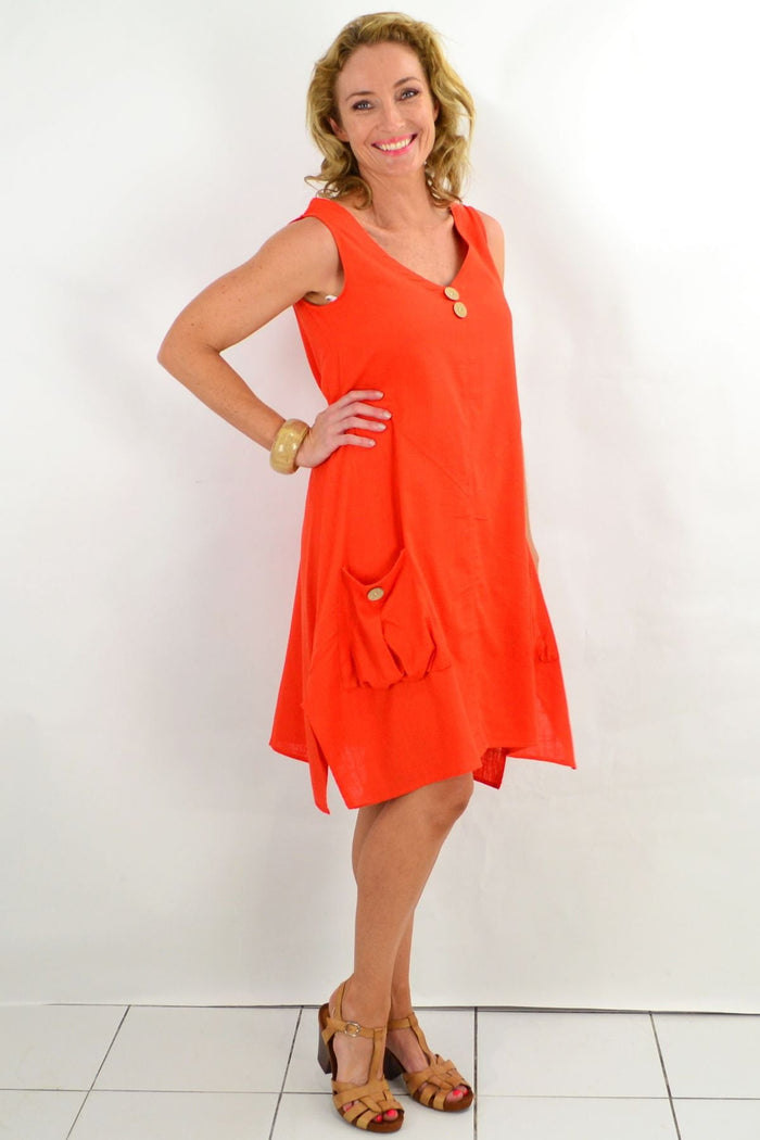 Vivid orange Ruby Rain tunic dress from Costa Rica, lightweight and flowing, displayed on a hanger against a neutral background.