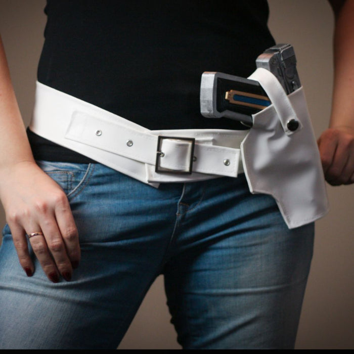 Person wearing a white belt with a holster on a plain background