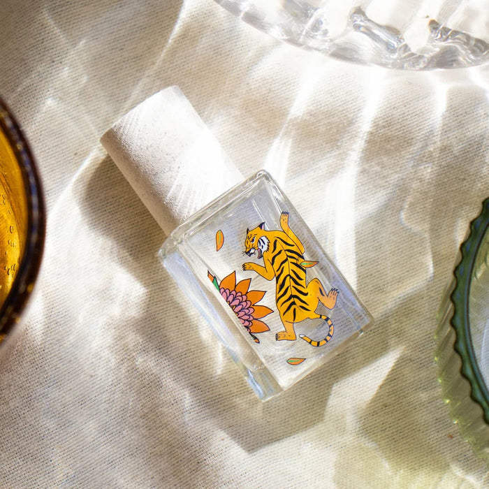 Small glass bottle with a tiger design on a textured surface