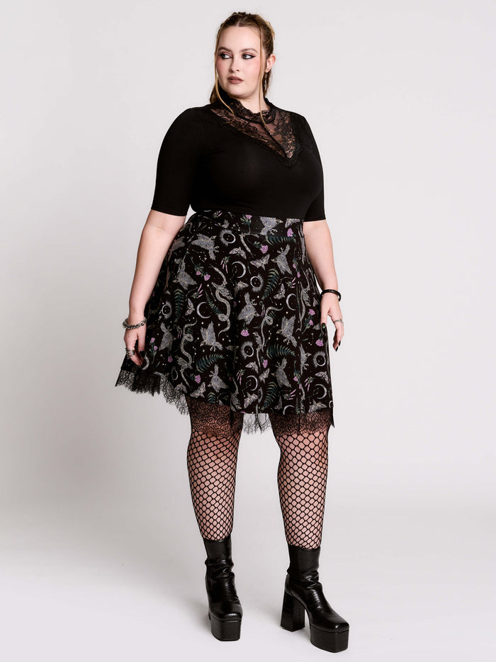 A  black flared skirt featuring a gray and purple gothic print with lace hem.