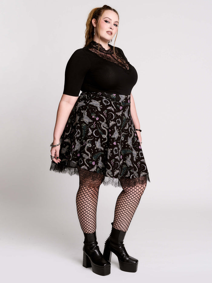A  black flared skirt featuring a gray and purple gothic print with lace hem.