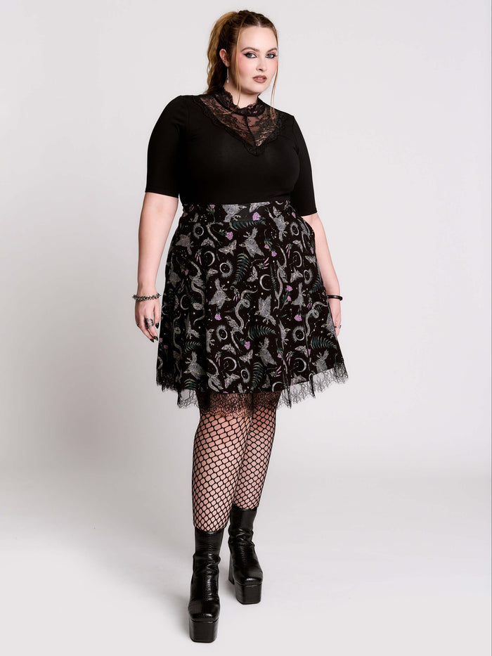 A  black flared skirt featuring a gray and purple gothic print with lace hem.