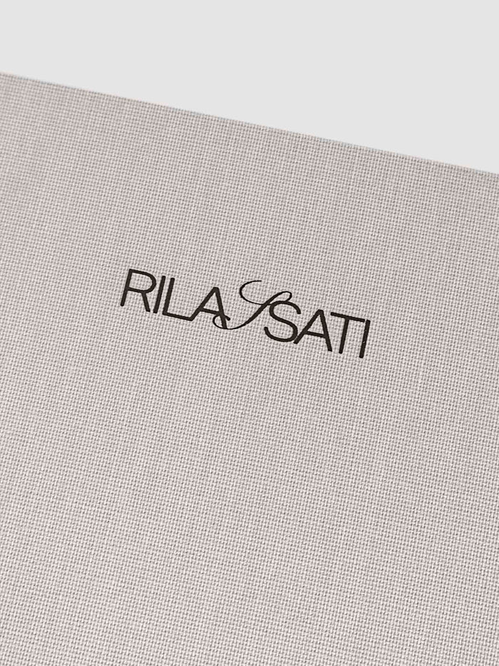 Closeup of fabric detailing and Rilassati printed logo on folio.