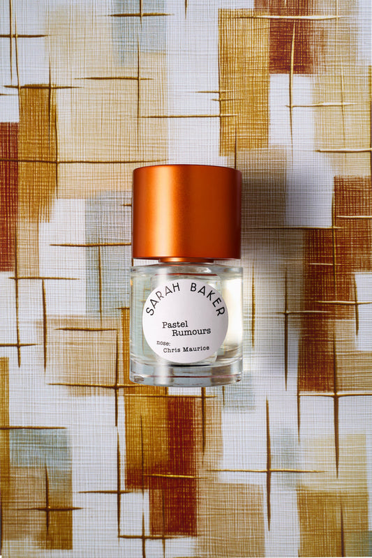 Sarah Baker Perfumes Pastel Rumours 50ml Eau de Parfum bottle with red cap on woven textile background