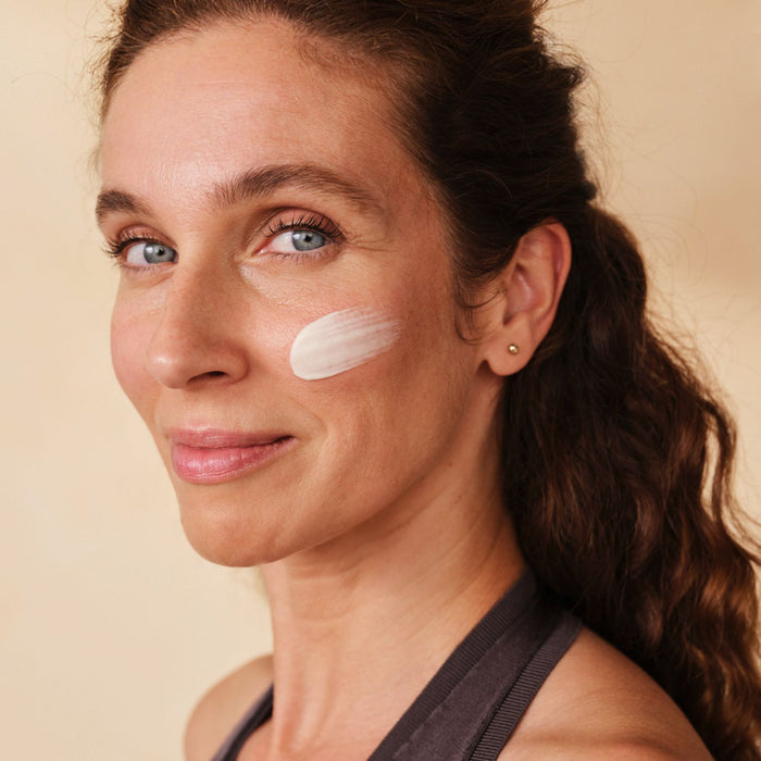 Mittelalte Frau mit Santaverde XINGU regenerating cream auf ihrem Wangenknochen