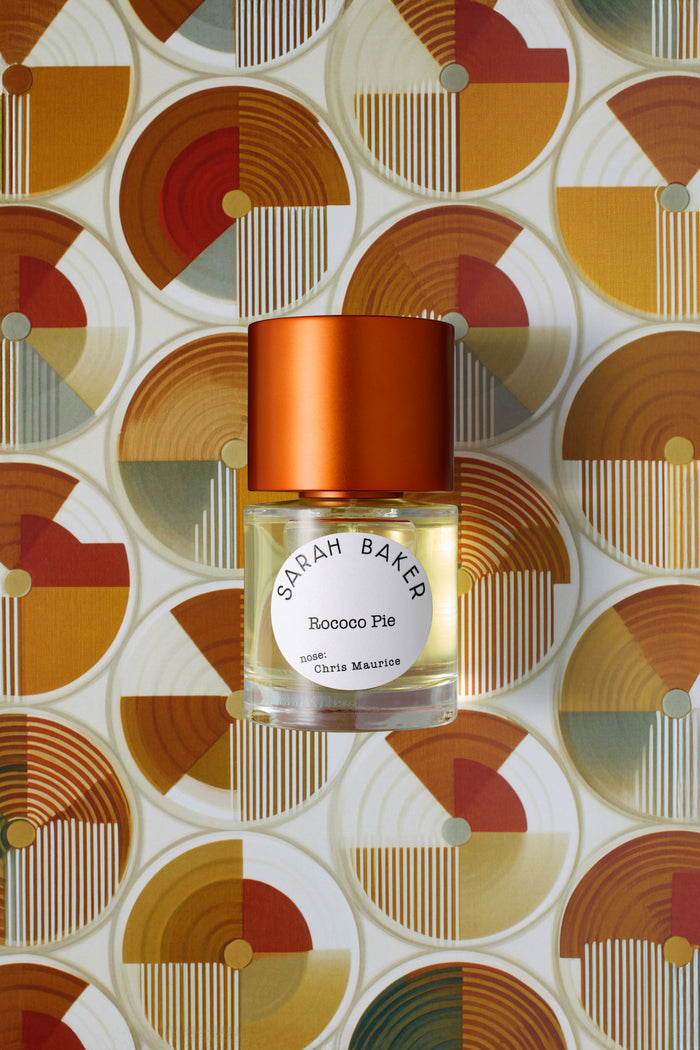 Sarah Baker Perfumes Rococo Pie 50ml Extrait de Parfum bottle with red cap on geometric art deco patterned background