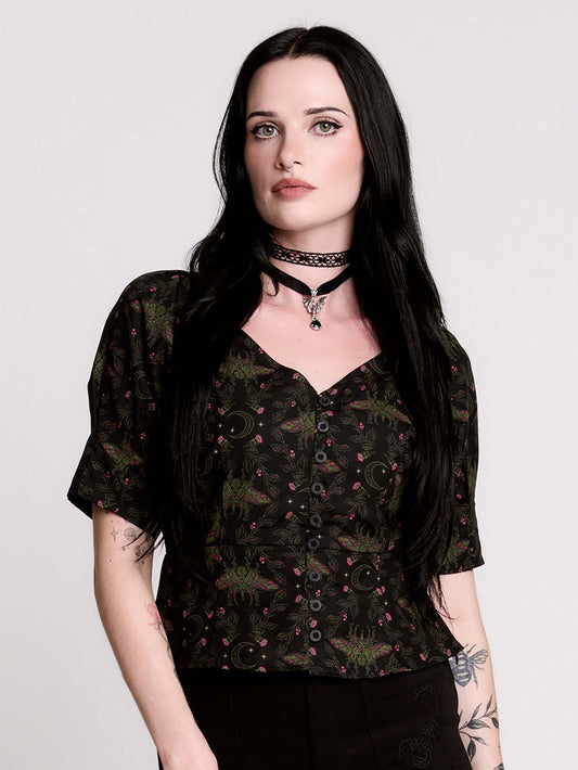 A short-sleeve button-up blouse featuring a dark green and black gothic pattern with pink accents.