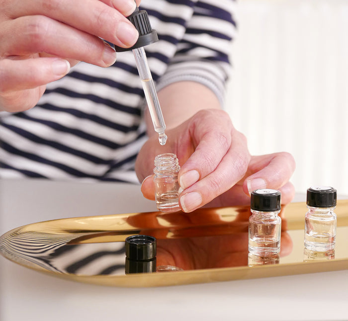 A hand pouring drops into a vial