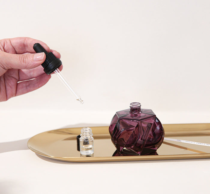 A hand pouring drops into a vial